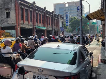 Scooter riders moving through a busy Taipei intersection