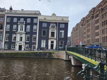 Narrow Amsterdam canal houses visibly leaning at different angles