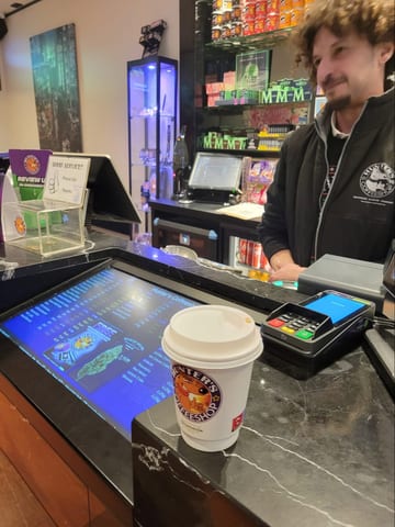A takeaway coffee cup on a counter in an Amsterdam coffee shop