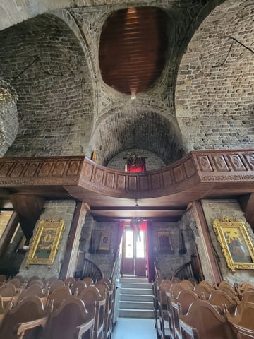 The stone nave, carved wooden seating, and painted icons inside the Church of Saint Lazarus