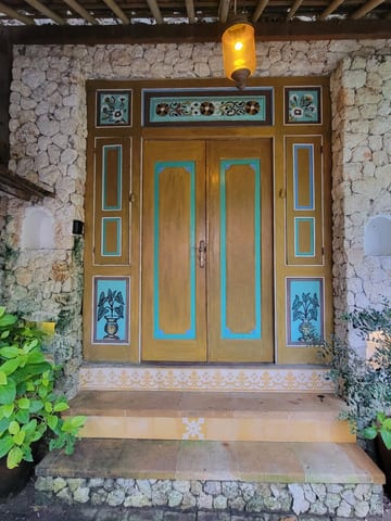 Decorated wooden double doors at the villa entrance