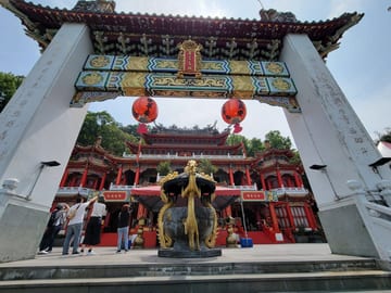 An ornate entrance arch and guardian statue at the Zhinan Temple Complex