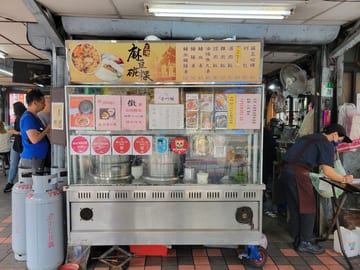 A Michelin-rated food stall with a large menu display in Taipei