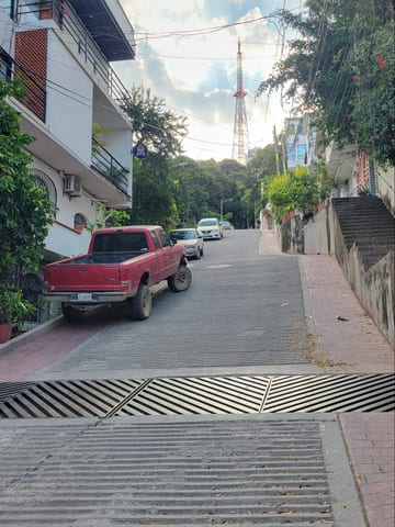 A steep grooved road climbing through the Puerto Vallarta hills