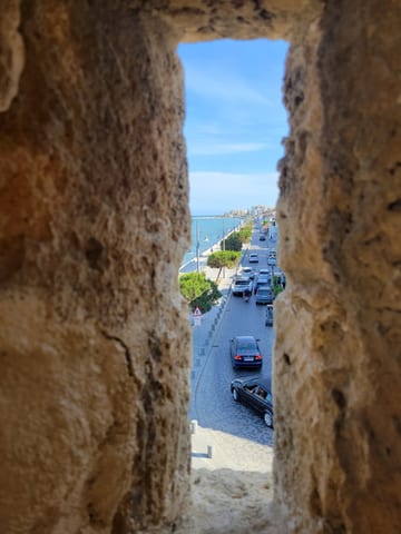 A Larnaca street seen through a narrow stone window in the fort