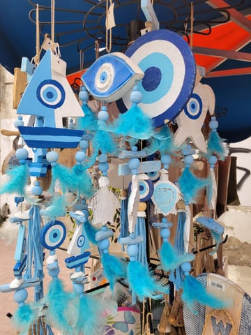 Blue-and-white evil eye wind chimes hanging at a market stall