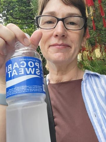 Stacy holding a bottle of Pocari Sweat on a hot day in Taipei
