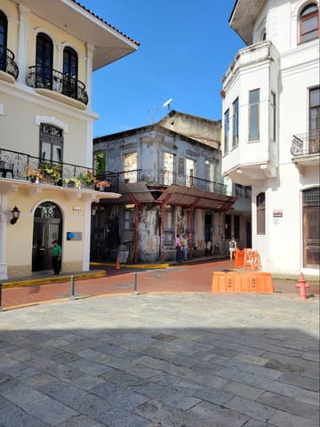 A sunny plaza bordered by restored and weathered Casco Viejo facades