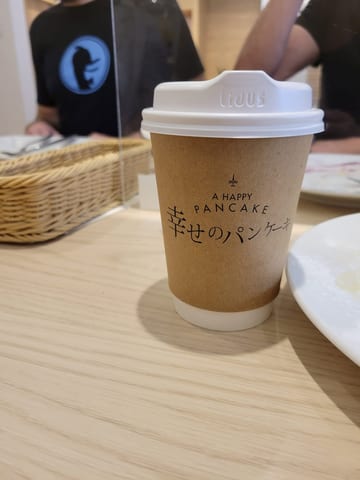 A coffee cup with a raised sipping lid at A Happy Pancake in Tokyo